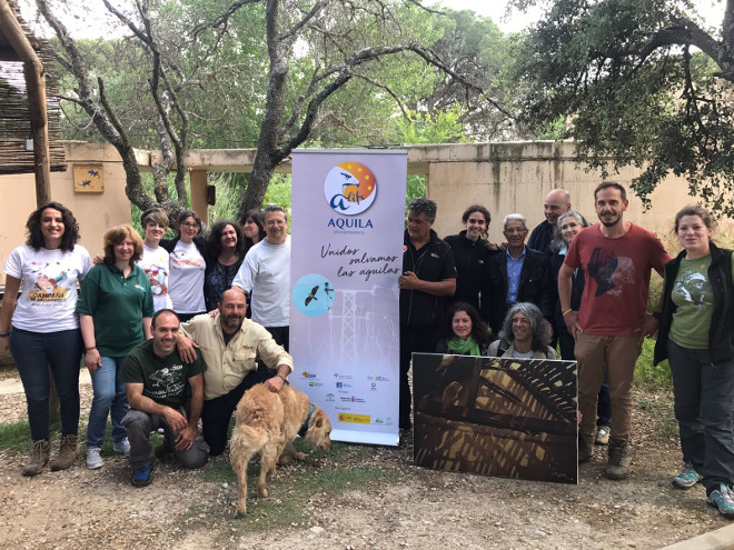 Trabajadores, voluntarios y amigos de GREFA posan en el Día del Águila junto a un cartel de nuestro proyecto