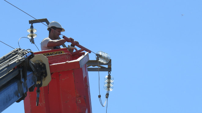 Un operario aísla el cable de un tendido eléctrico peligroso para las aves.