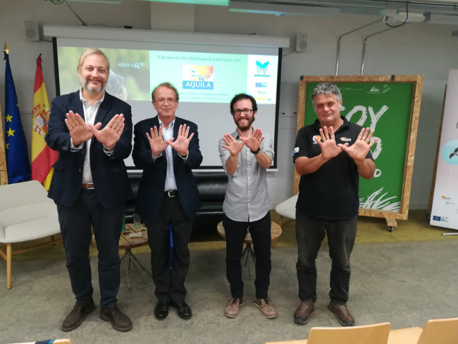 De izquierda a derecha, Ignacio Torres (Fundación Biodiversidad), Miguel Aymerich (Ministerio para la Transición Ecológica), Manuel Galán (AQUILA a-LIFE) y Ernesto Álvarez (GREFA), hacen con sus manos el símbolo de la mariposa con motivo del Día Europeo de la Red Natura 2000.