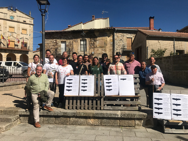 Miembros de AQUILA a-LIFE y del Proyecto Monachus, junto con otros colaboradores y simpatizantes de estos proyectos, en la plaza de Huerta de Arriba. Los carteles contienen las siluetas con las marcas alares de los buitres negros liberados.