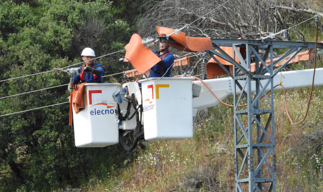 Dos operarios aíslan un apoyo eléctrico en un tendido de Iberdrola situado en una zona de la Comunidad de Madrid frecuentada por águilas de Bonelli reintroducidas.