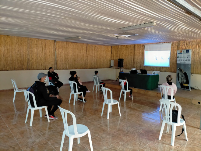 Asistentes a una charla durante el Día del Águila en Mallorca, respetando la distancia social frente al COVID-19.