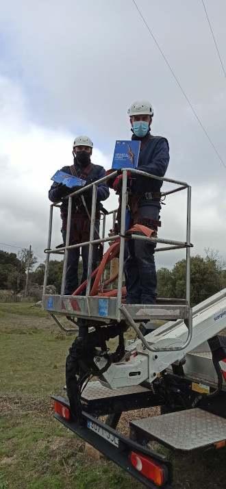 De izquierda a derecha, operarios durante la corrección de un tendido peligroso para las aves, y Luis Alonso, concejal del medio ambiente de Fresnedillas de la Oliva (Madrid), muestran los ejemplares de Libro Blanco que han recibido del proyecto AQUILA a-LIFE.