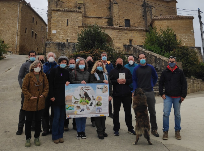 Asistentes a la reunión informativa celebrada el pasado 9 de abril en Echarren de Guirguillano (Navarra), con un cartel del proyecto AQUILA a-LIFE.