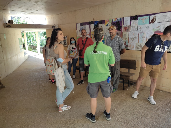 Una educadora de GREFA enseña a un grupo de visitantes los dibujos hechos por niños y jóvenes para la 3ª edición de la “Muestra de Dibujos y Trabajos Artísticos del Águila de Bonelli”, convocada por AQUILA a-LIFE.
