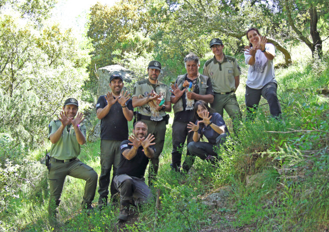 Equipo y colaboradores de AQUILA a-LIFE (GREFA, Agentes Forestales y TRAGSA) hacen el gesto de la mariposa mientras sujetan a dos pollos de águila de Bonelli nacidos en la Comunidad de Madrid, para su marcaje con GPS.